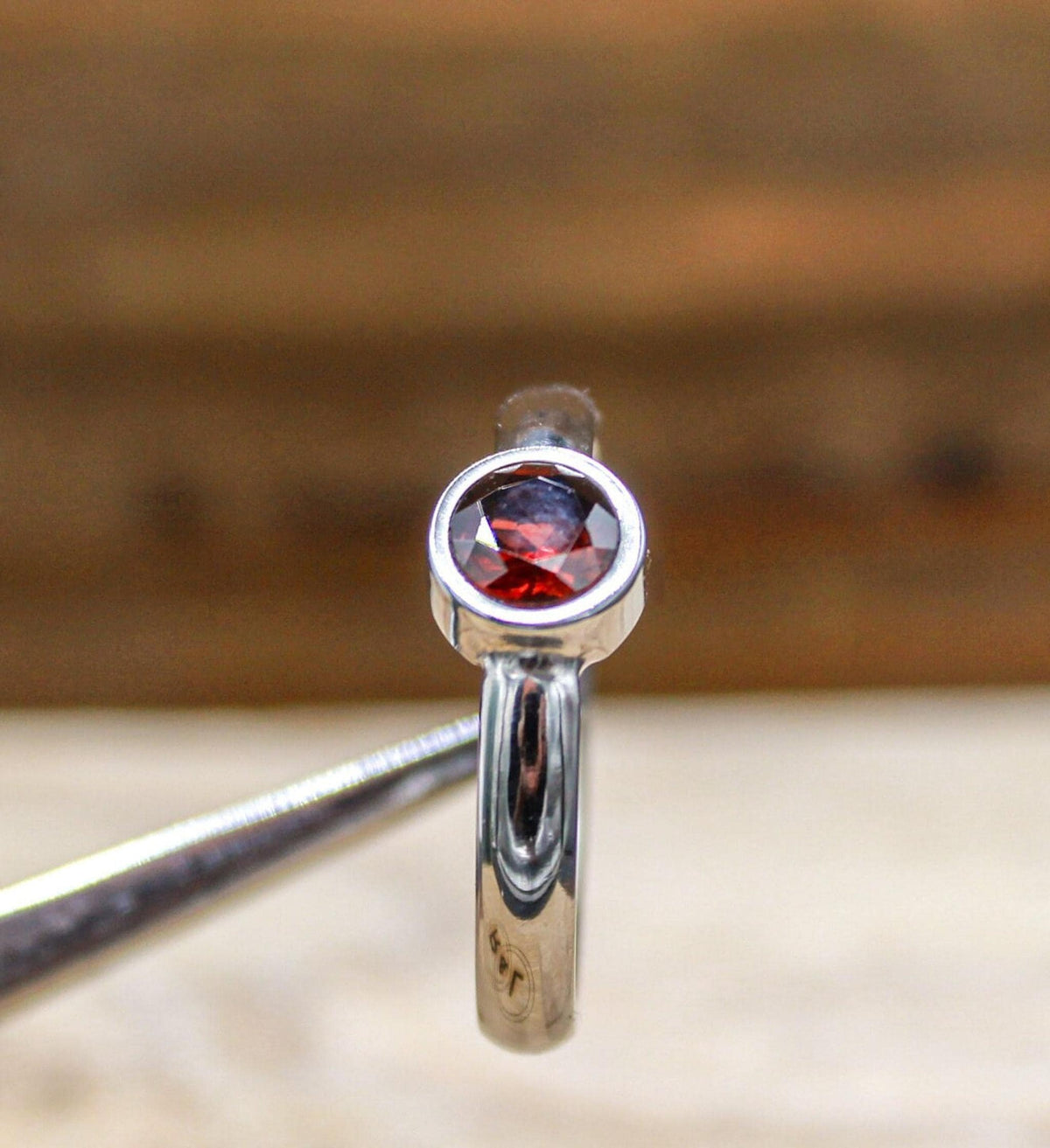 Handmade garnet bezel set titanium ring. 5mm round faceted garnet ring. Custom made titanium wedding band.