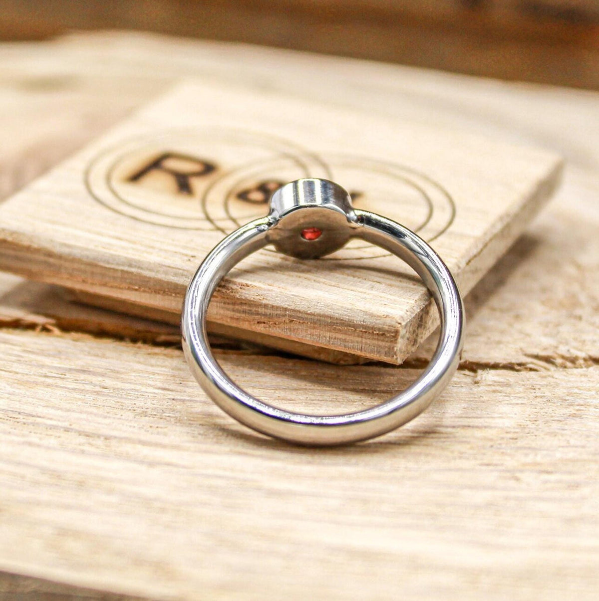Handmade garnet bezel set titanium ring. 5mm round faceted garnet ring. Custom made titanium wedding band.