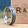 Made to order men's titanium wedding ring with dinosaur bone, opal and purple wood inlays.