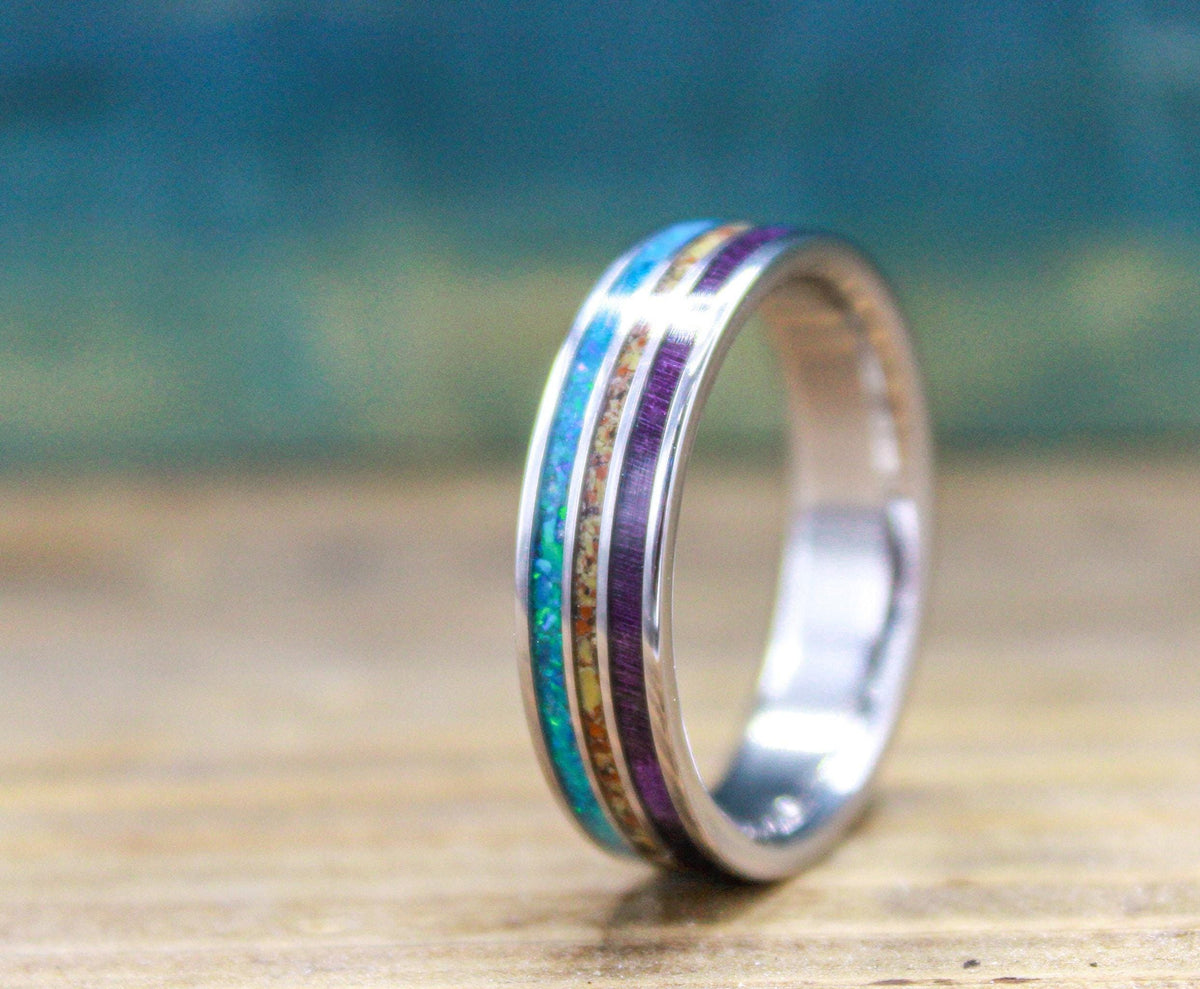 Made to order men's titanium wedding ring with dinosaur bone, opal and purple wood inlays.