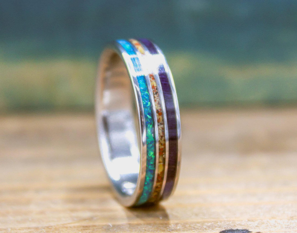 Made to order men's titanium wedding ring with dinosaur bone, opal and purple wood inlays.