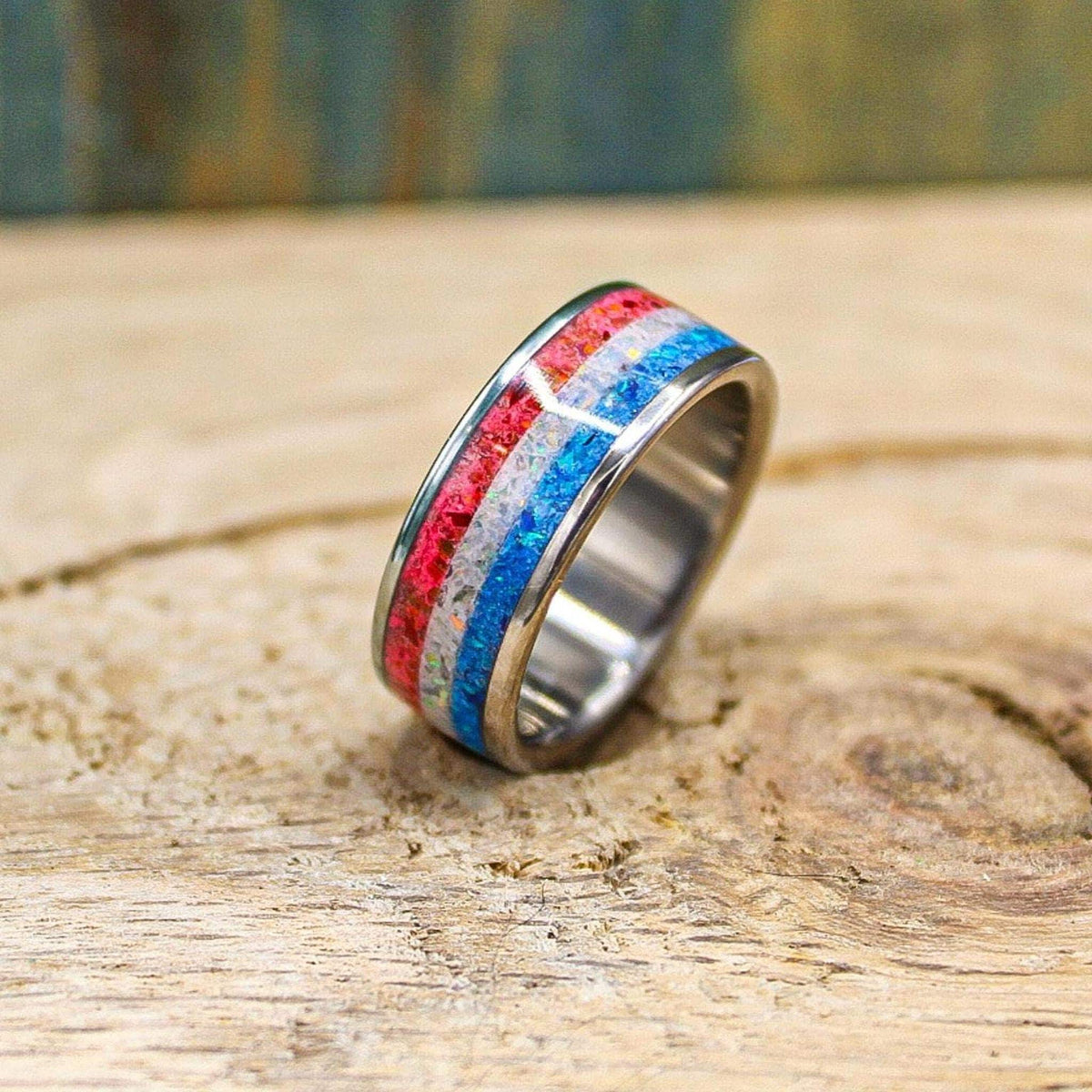 An angled view of the ring standing upright on the rustic surface, with soft focus on the blurred wooden backdrop behind it.