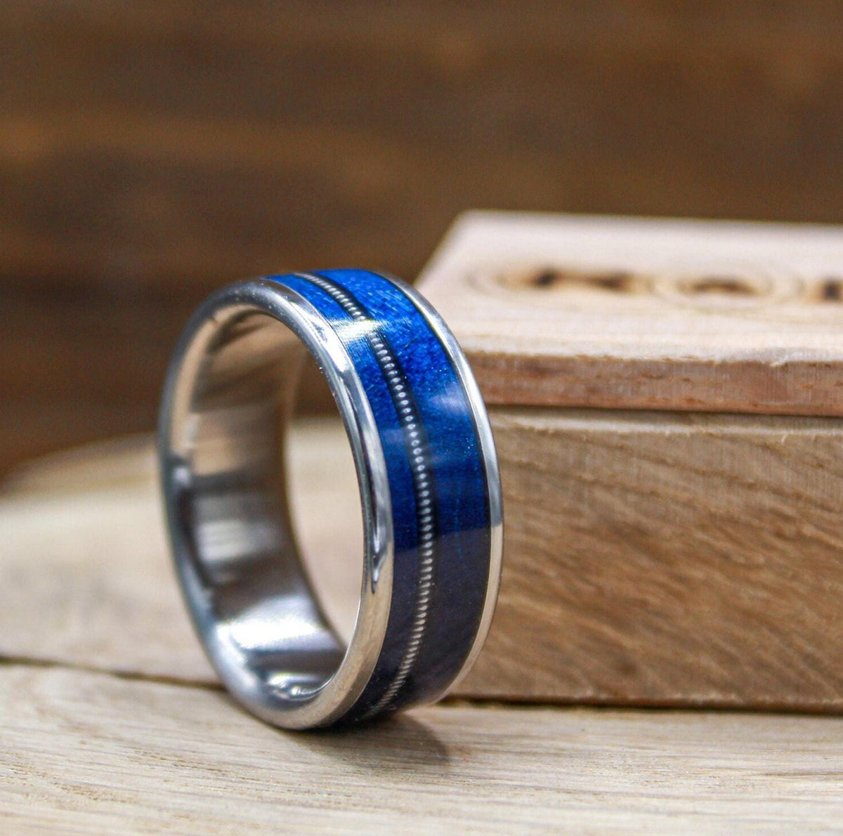 Titanium and blue wood ring for men with guitar string inlay.