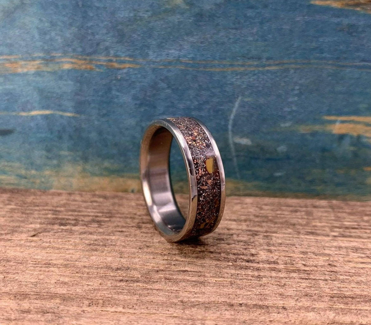 Men's aerospace titanium wedding band featuring meteorite and dinosaur bone inlay, crafted by RobandLean's rings.
