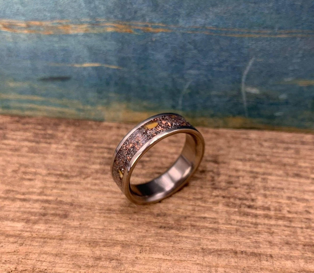 Men's aerospace titanium wedding band with meteorite and dinosaur bone inlay, crafted by RobandLean's rings.