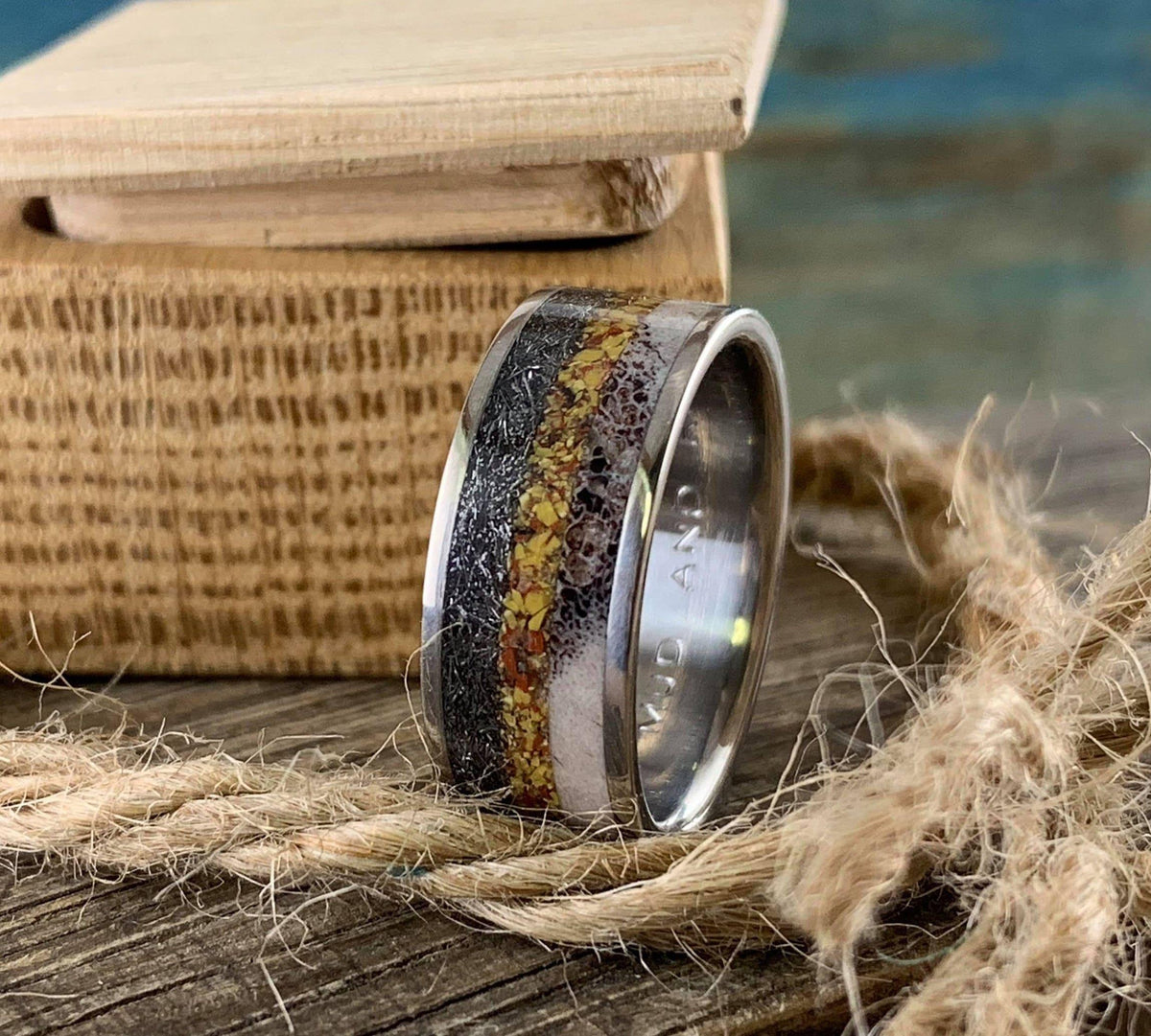 Titanium men's wedding band featuring meteorite, dinosaur bone, and deer antler in a sleek design by RobandLean's rings.
