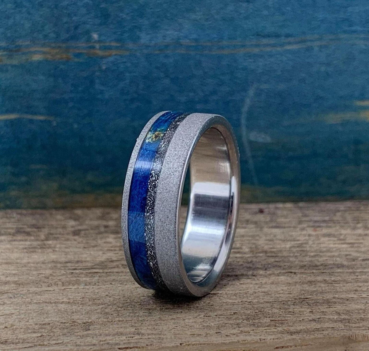 Titanium men's wedding band with meteorite and blue wood inlays, crafted by RobandLean's rings.