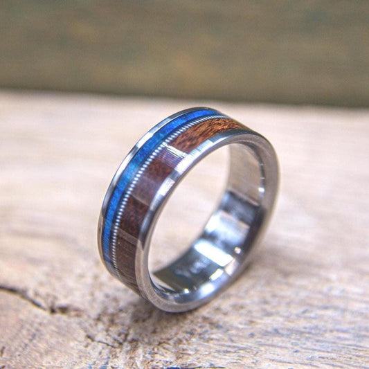 Men's titanium wedding band with blue burl and rosewood accents, featuring a guitar string design from RobandLean's rings.