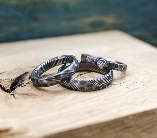 Damascus steel wedding set with his and hers bands and a diamond engagement ring from RobandLean's rings.