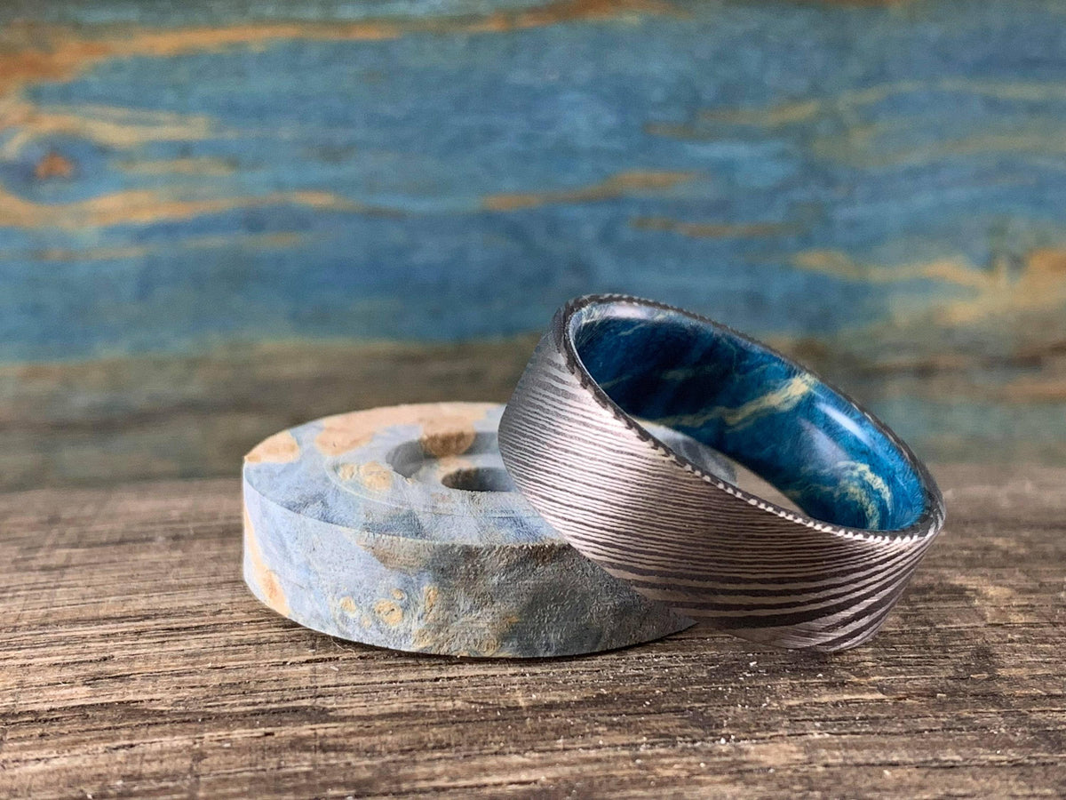 Custom Damascus steel wedding band with blue box elder wood inlay, crafted by RobandLean's rings, size 4.5mm.