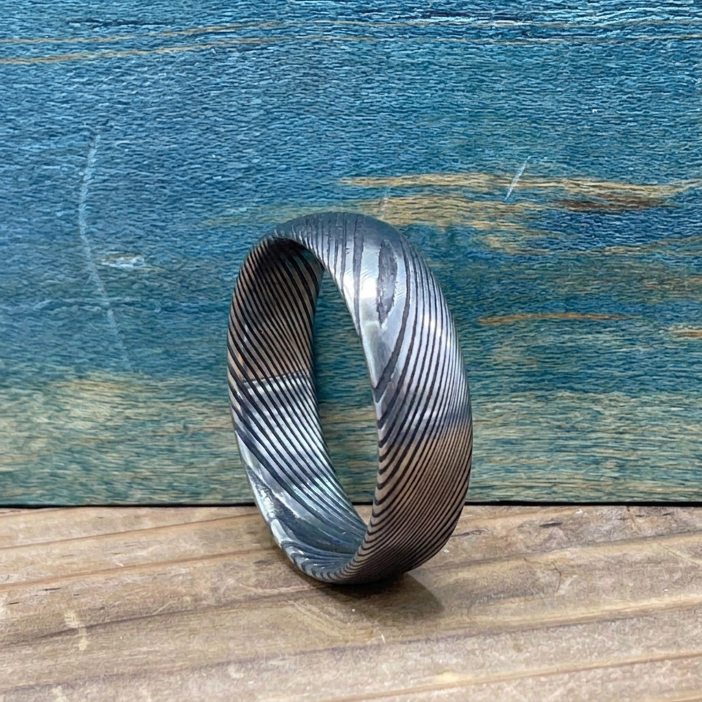 Damascus Steel wedding band by RobandLean's Rings with a square-shaped design and intricate pattern, suitable for couples' wedding rings.