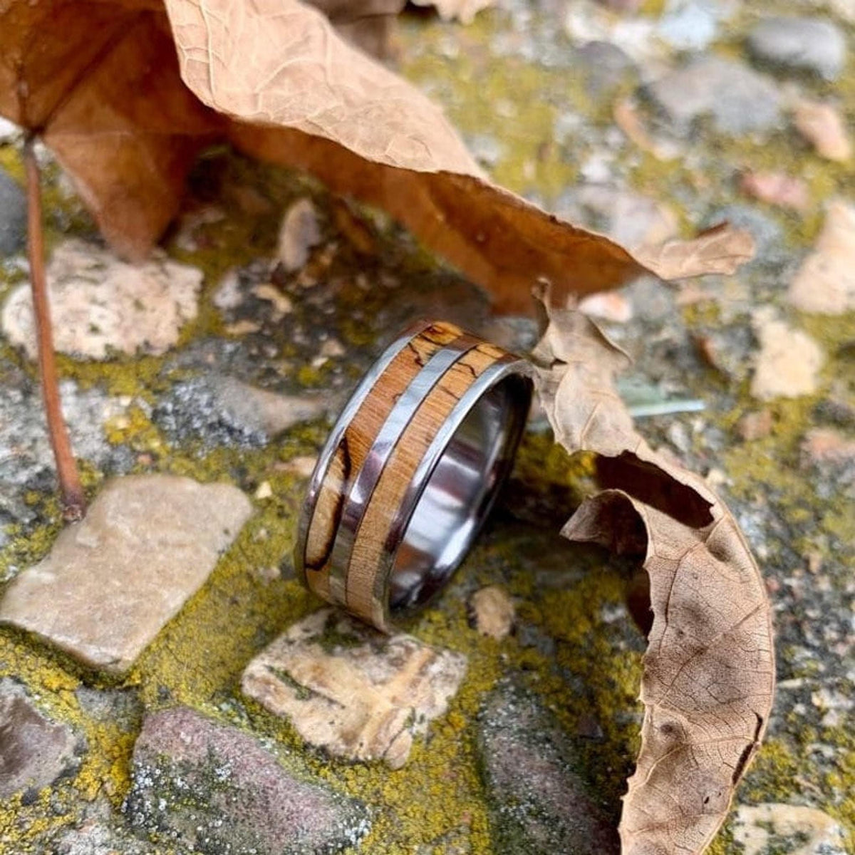 Men's titanium wedding band with pecan wood inlay, western-inspired design from RobandLean's rings, showcasing a sleek, durable style.