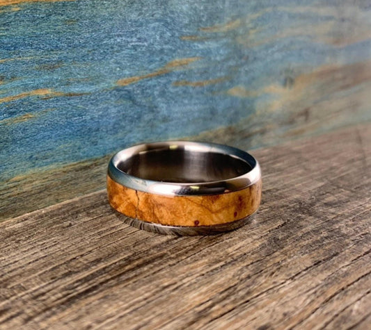 Mens titanium wedding band with black ash burl inlay, custom-made ring from RobandLean's rings, showcasing polished and textured details.