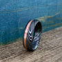 Damascus steel and copper men's wedding band with stainless steel finish, featuring intricate pattern and inlay design.