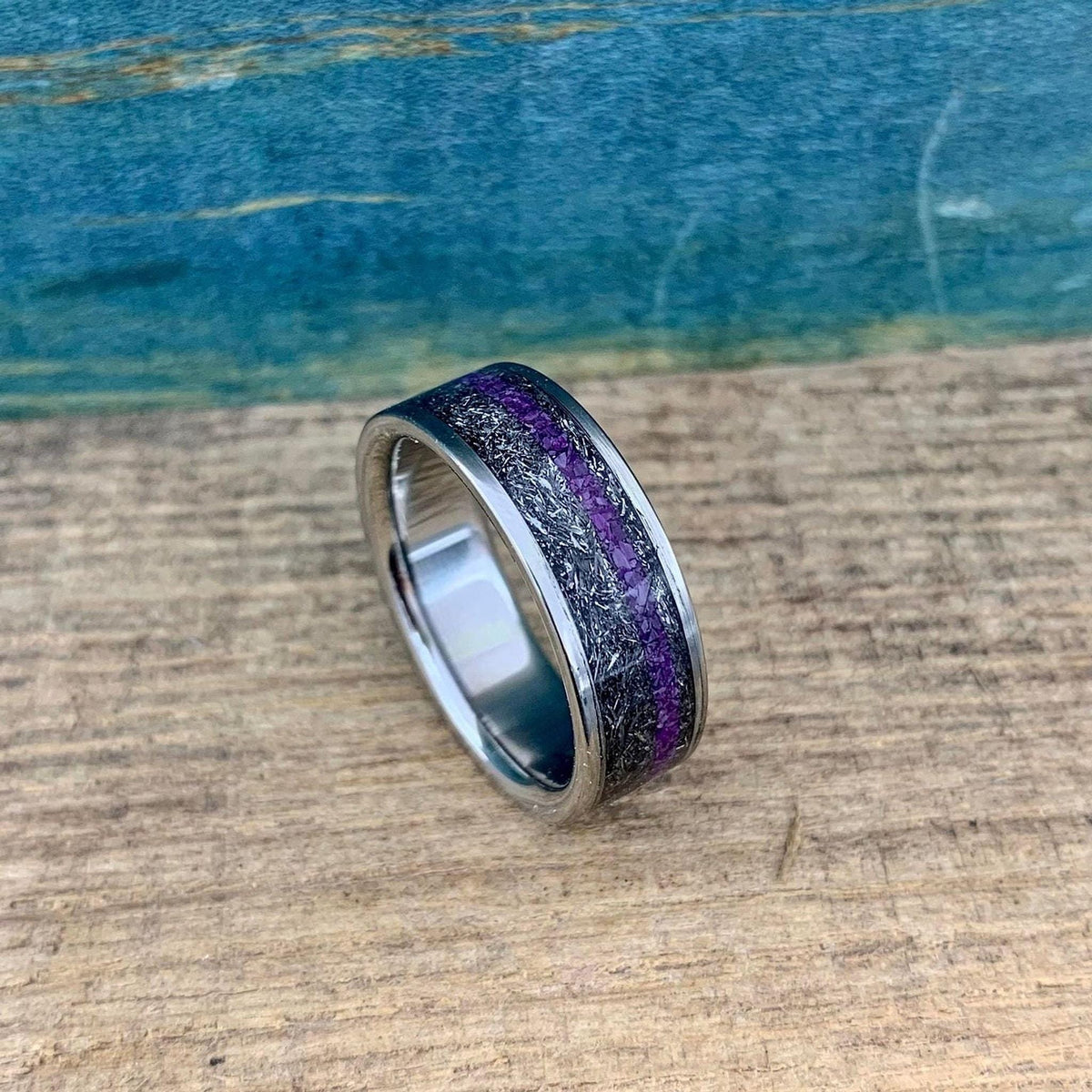 Men's titanium wedding band with Gibeon meteorite inlay and purple Sugilite, showing the ring's detailed design and polished finish.