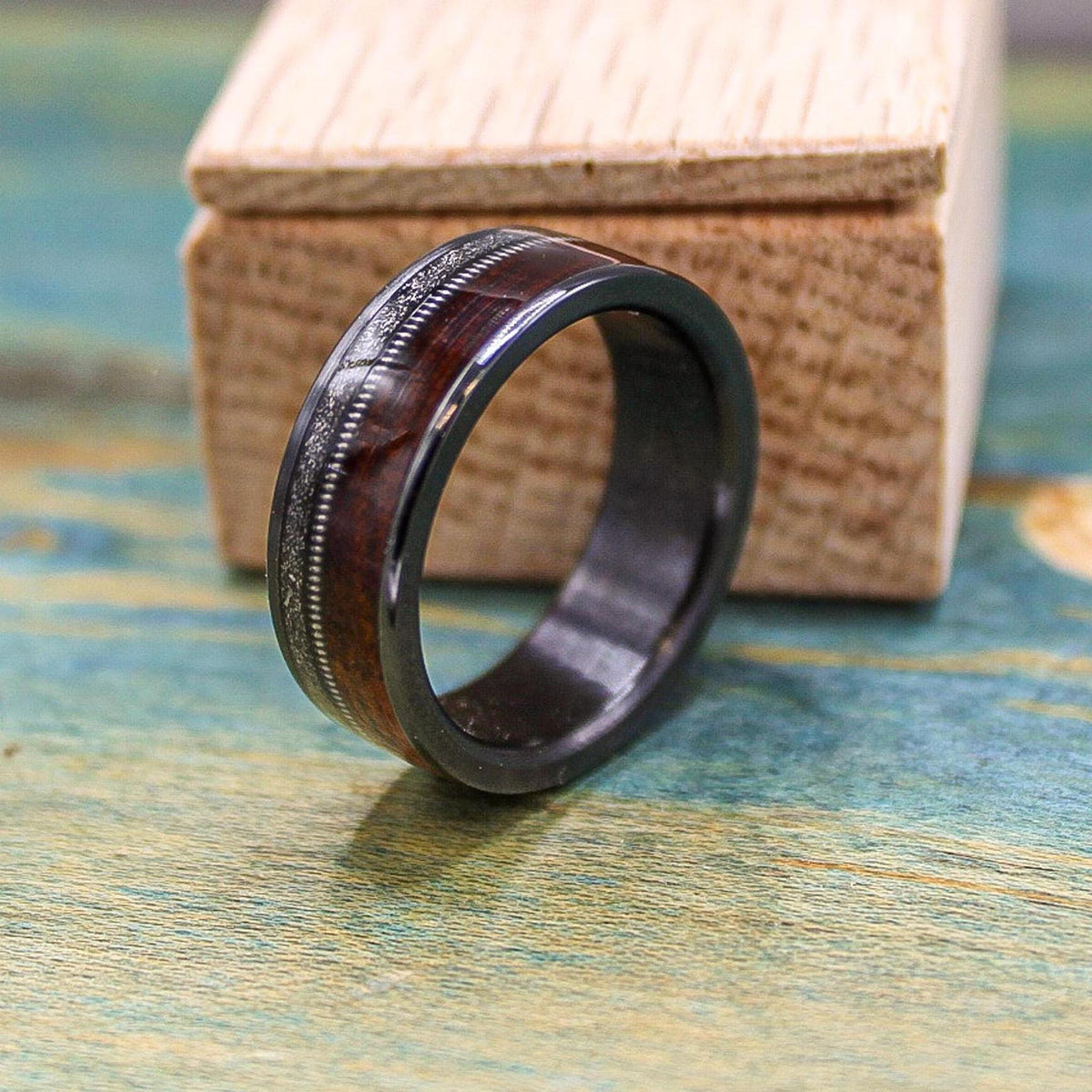 Black titanium wedding band with rosewood inlay, meteorite detail, and guitar string accent, designed for men by RobandLean's rings.