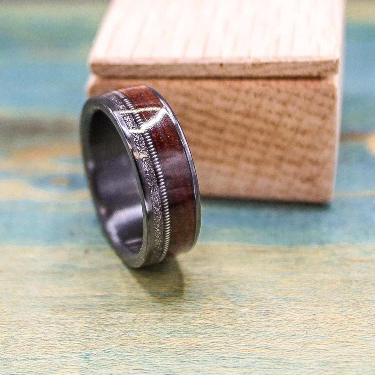 Black titanium wedding band with rosewood inlay, meteorite accents, and guitar string detail from RobandLean's rings.