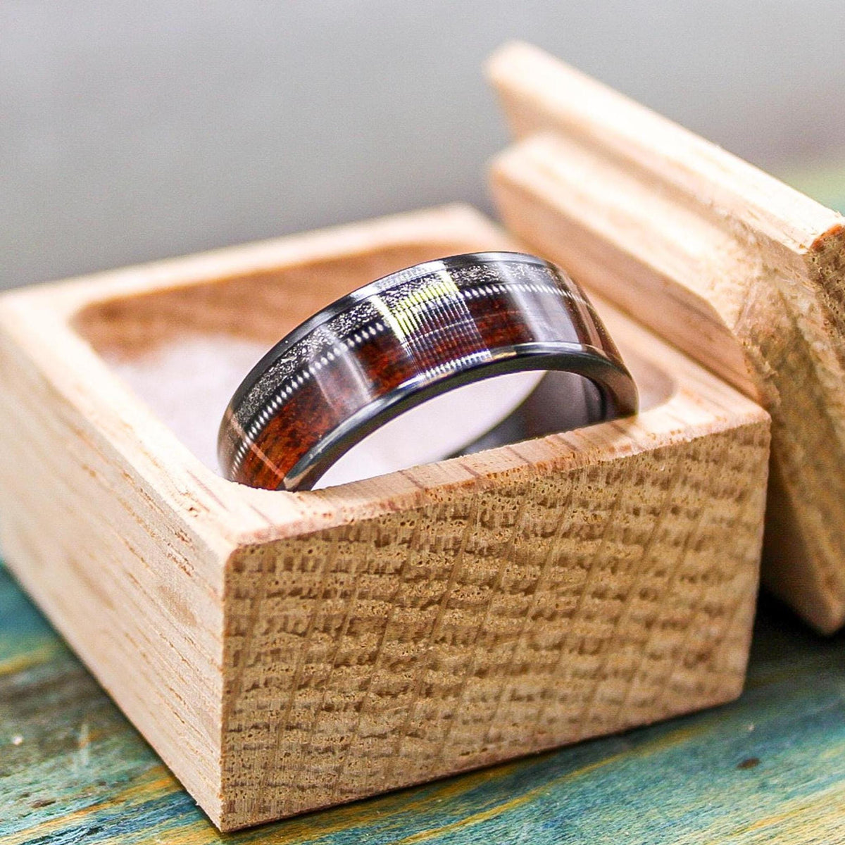 Black titanium wedding band with rosewood inlay, meteorite accents, and guitar string detail, men's RobandLean's ring.
