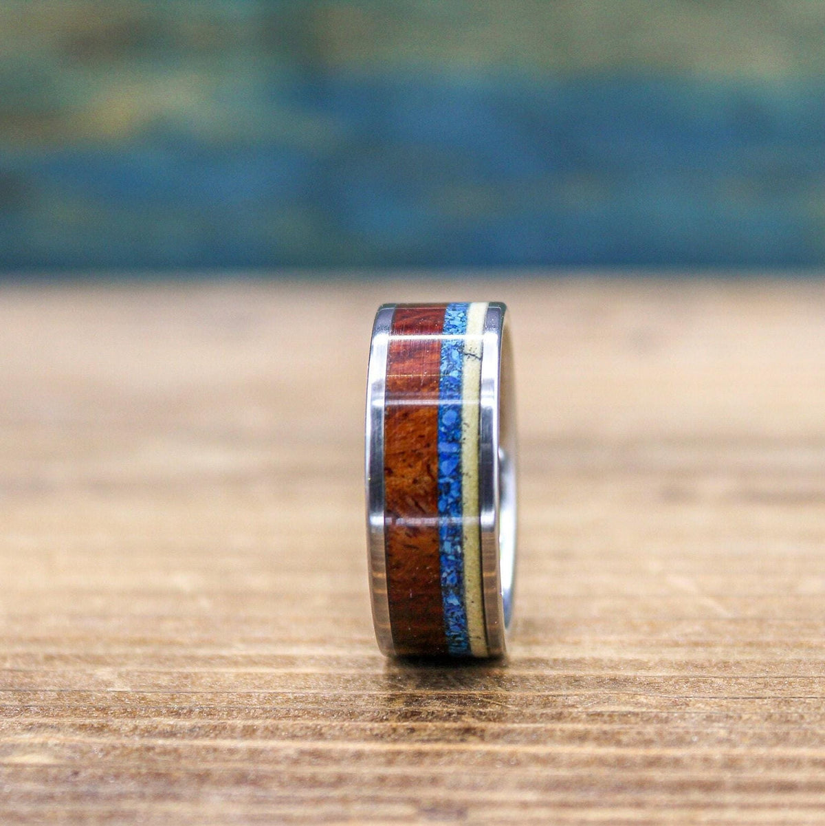 Titanium men's wedding band with Amboyna burl wood and turquoise inlay, featuring a sleek, polished design for him.