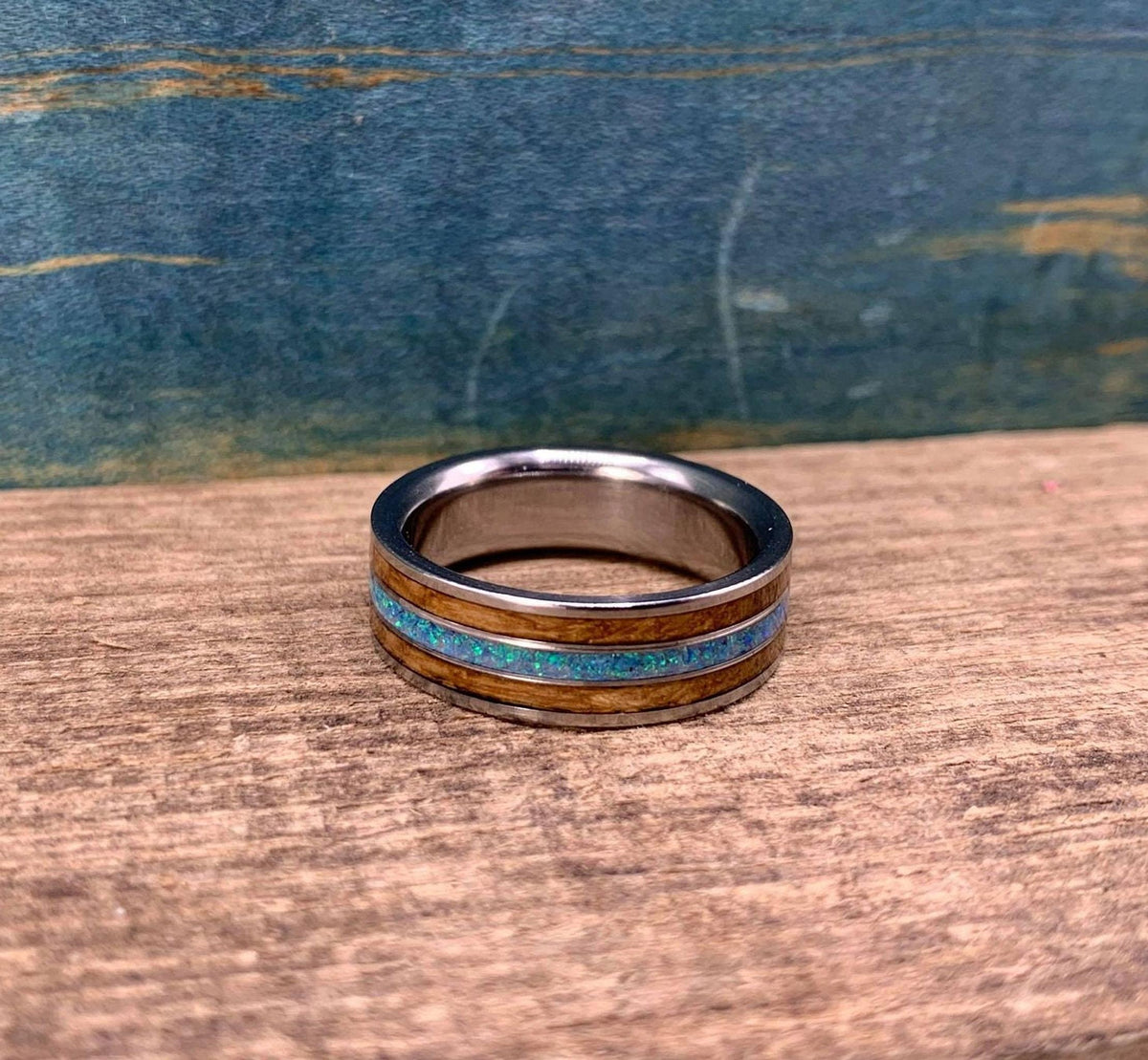 Titanium wedding band for him with whiskey barrel wood and opal, engraved, by RobandLean's rings.