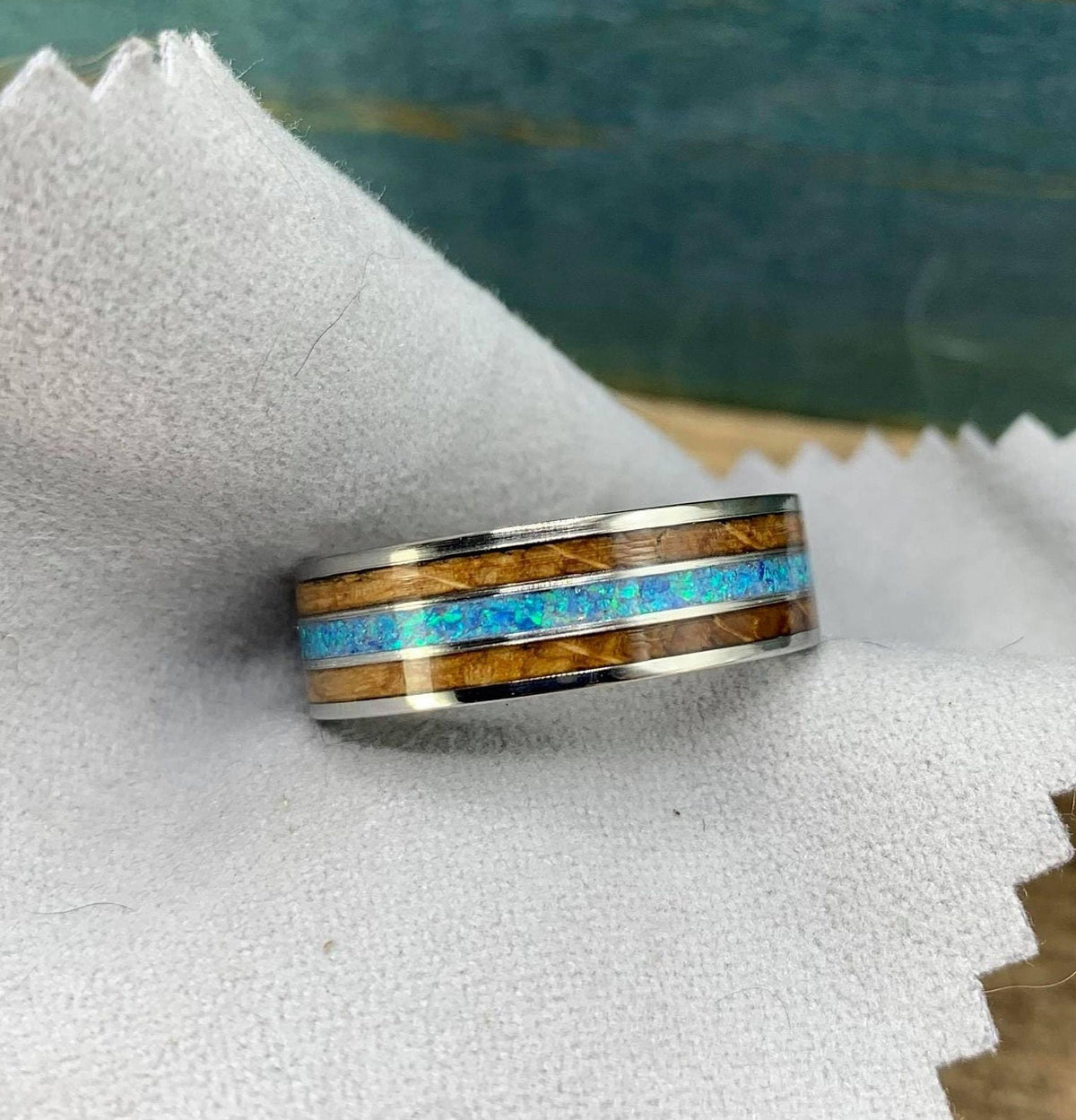Titanium wedding band for men with whiskey barrel wood inlay and opal, engraved, from RobandLean's rings.