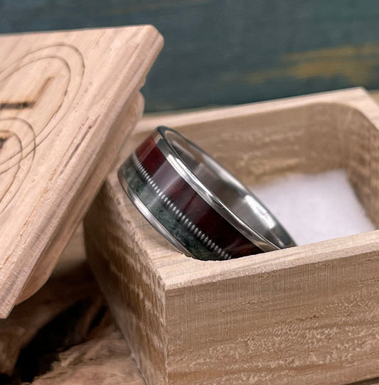 Men's titanium wedding band with redwood, moss agate, and guitar string inlays, crafted by RobandLean's rings.