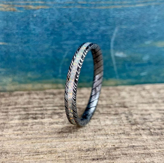 Dainty 3mm opal wedding band in Damascus steel by RobandLean's rings, showcasing a sleek, modern engagement ring design.