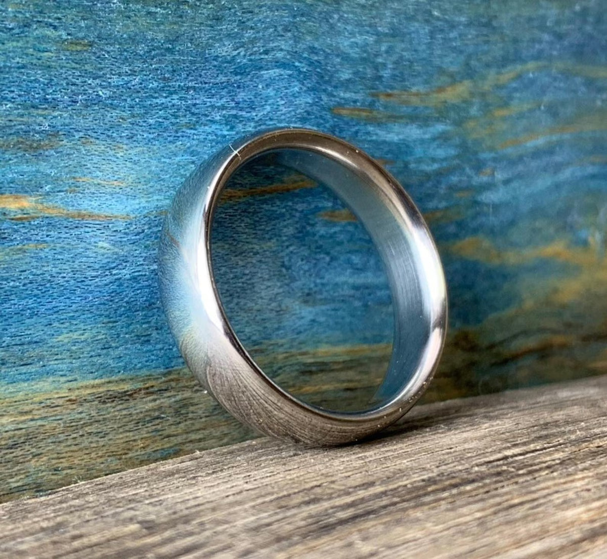 Side angle view of comfort-fit polished titanium band showing rounded edges
