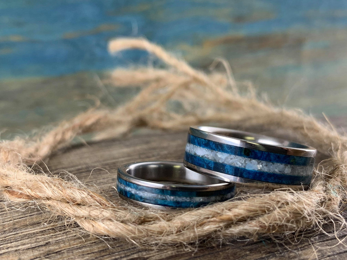 Matching his and hers titanium wedding bands with blue wood and pearl inlays, designed by RobandLean's rings.