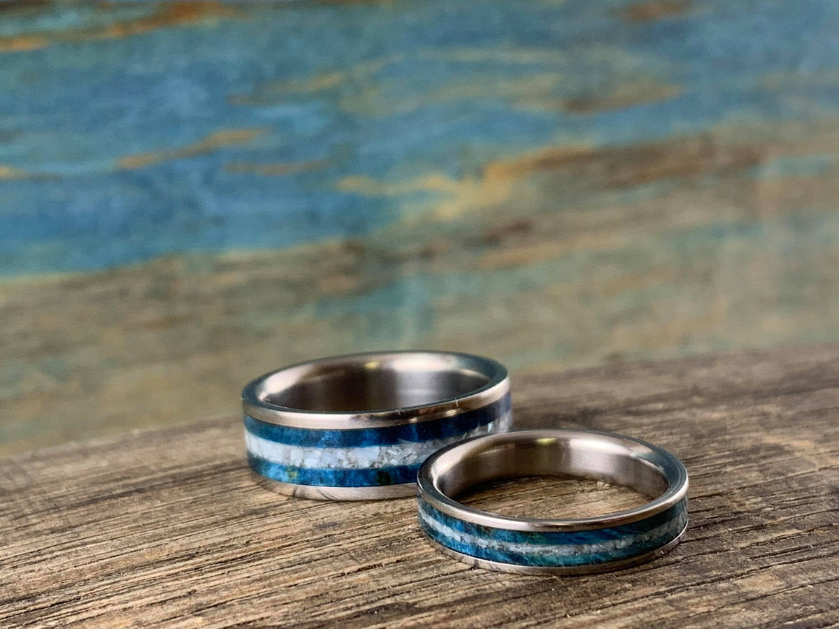 Matching his and hers titanium wedding bands with blue wood and pearl inlays, custom-designed by RobandLean's rings.