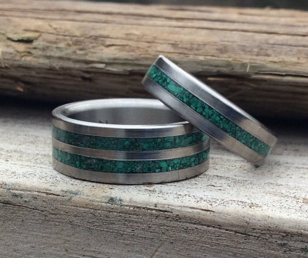 Matching titanium couples rings with green malachite accents, designed for him and her, in a unique wedding band set.