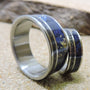 His and hers titanium wedding band set with meteorite and blue wood inlays, showcasing matching rings by RobandLean.