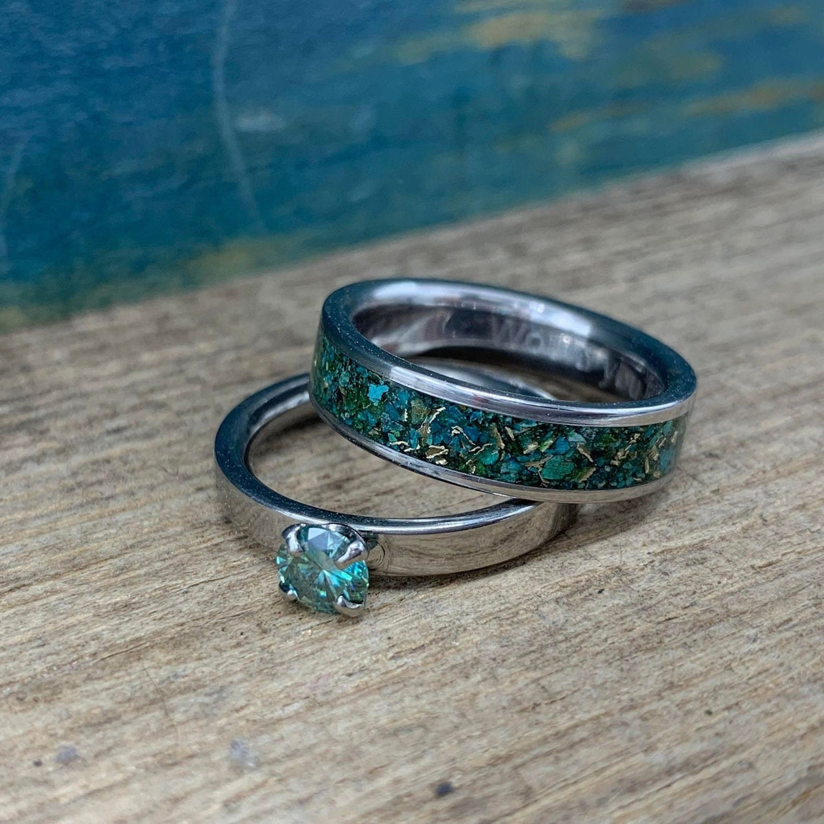 RobandLean's The Hobgoblin set featuring blue-green moissanite engagement rings with intricate band designs and vibrant gemstone settings.