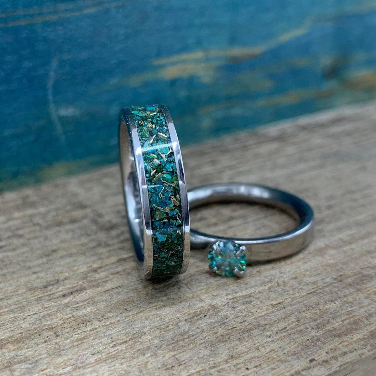RobandLean's Hobgoblin set featuring blue-green moissanite engagement rings with intricate band details.