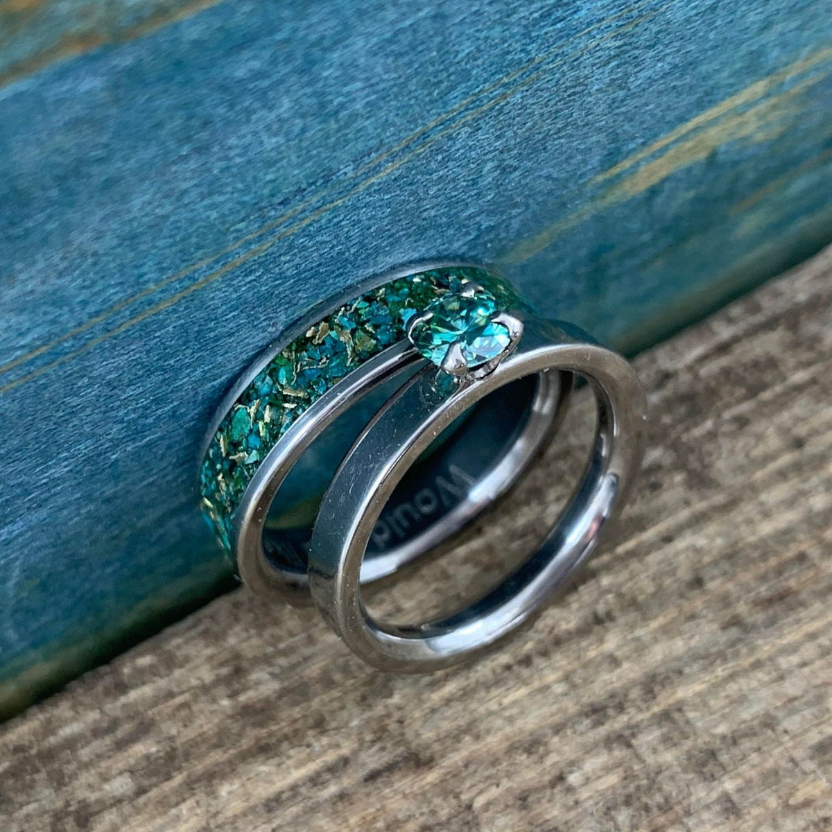 RobandLean's Hobgoblin set featuring blue-green moissanite engagement rings with intricate silver bands and detailed gemstone settings.