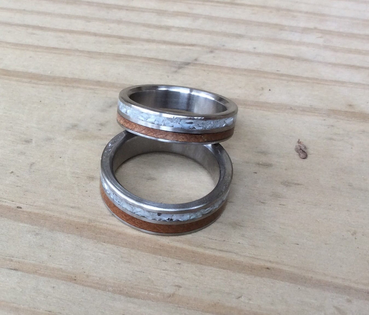 Titanium ring by RobandLean with inlays of mother of pearl and ancient Kauri wood, showcasing intricate craftsmanship.