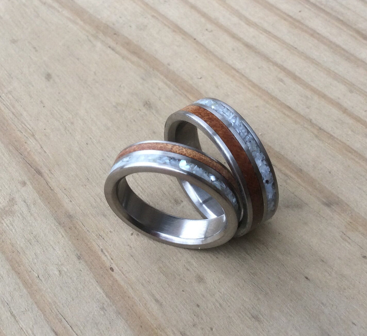 RobandLean's titanium ring with inlays of mother of pearl and ancient Kauri wood, showcasing a detailed, elegant design.