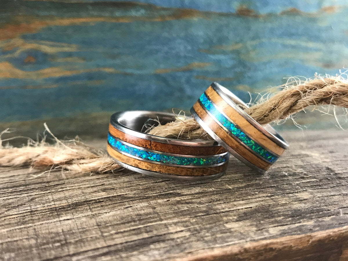 RobandLean's titanium ring featuring whiskey barrel wood inlay and blue-green opal, showcasing a unique, handcrafted jewelry design.