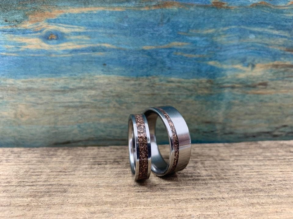 Elegant titanium rose gold wedding bands set by RobandLean, featuring matching his and hers rings with a sleek, polished finish.