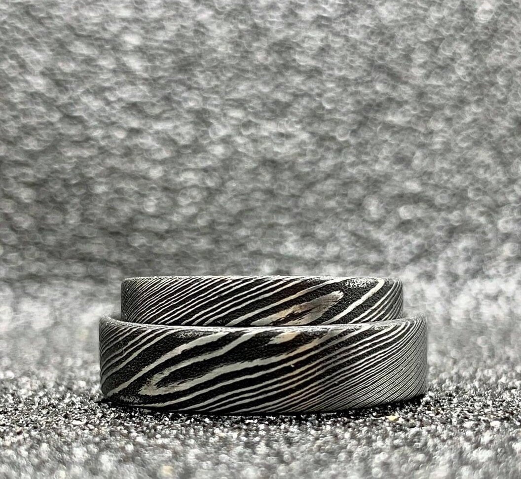 Custom handcrafted Damascus steel wedding band by RobandLean's rings, featuring unique layered metal patterns.