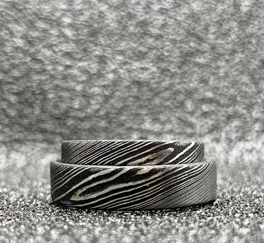 Custom handcrafted Damascus steel wedding band by RobandLean's rings, featuring unique layered metal patterns.