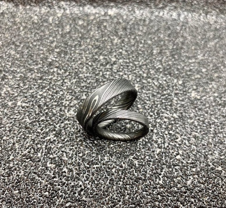 Handcrafted Damascus steel wedding band by RobandLean's rings, featuring intricate patterns and a polished finish.
