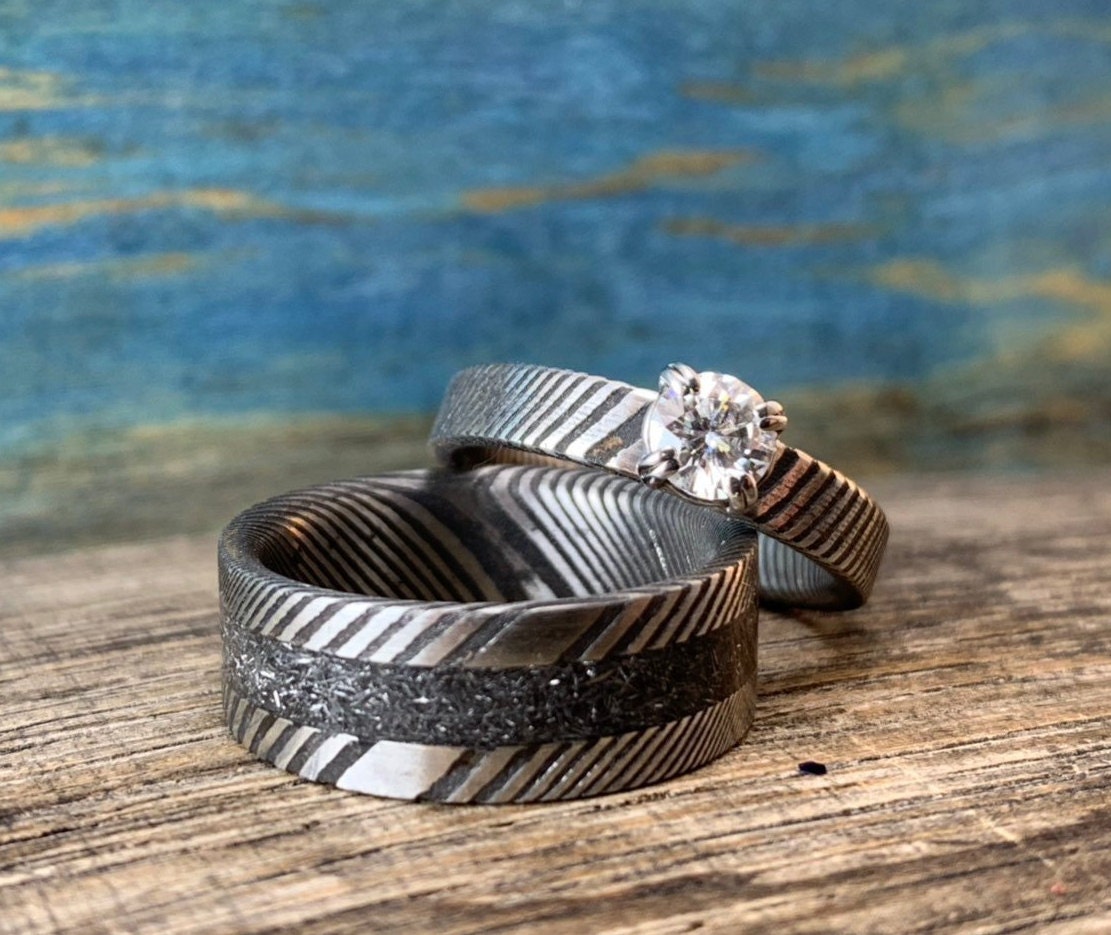 Damascus steel wedding band set with meteorite accents and moissanite stones, crafted by RobandLean's rings for elegant couples.