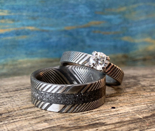 Damascus steel wedding band set with meteorite accents and moissanite stones, crafted by RobandLean's rings for elegant couples.