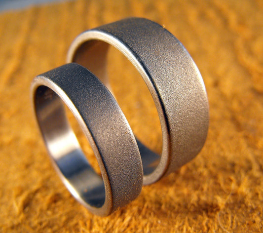 His and hers titanium wedding bands set by RobandLean’s Rings, custom-made couples rings with engraved details.