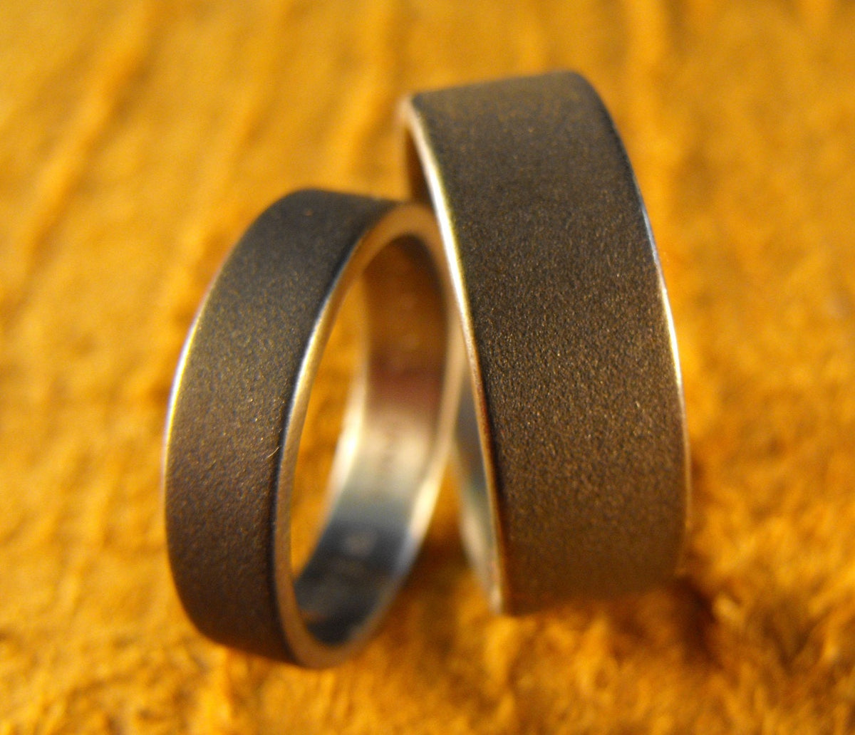His and hers titanium wedding bands set by RobandLean's rings, custom-made couples rings with engraved designs.
