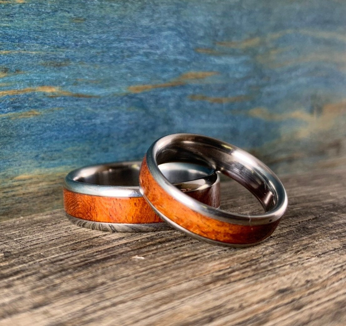 RobandLean's matching Amboyna Burl titanium wedding rings with a smooth finish and natural wood grain pattern.