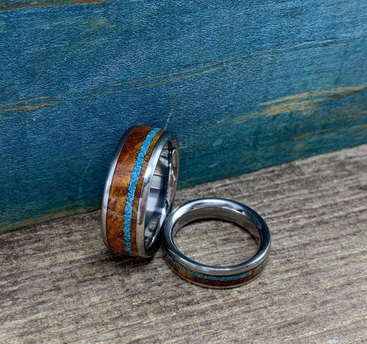 Matching titanium wedding bands with desert ironwood and turquoise inlays by RobandLean's rings, showcasing their detailed craftsmanship.